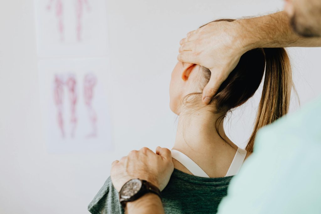 pexels photo 4506162 4506162 Back view of crop faceless bearded orthopedist in wristwatch checking up neck of anonymous lady while standing in front of wall with paper drawings representing body anatomy